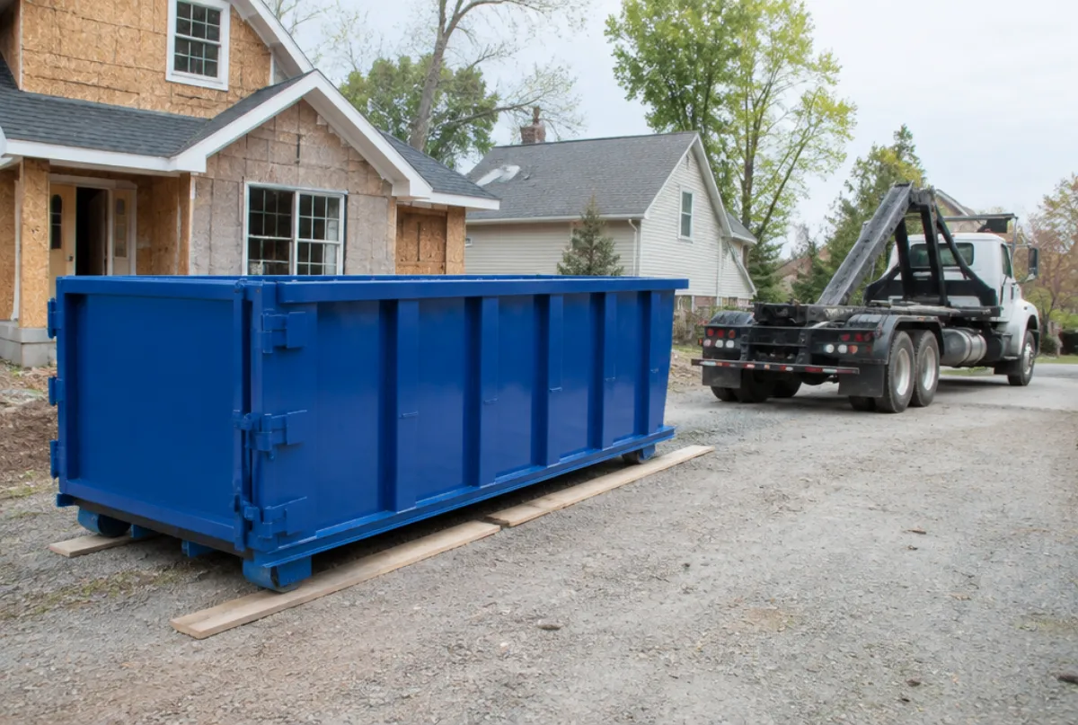 Roll off dumpster dropped in a driveway beside a renovation